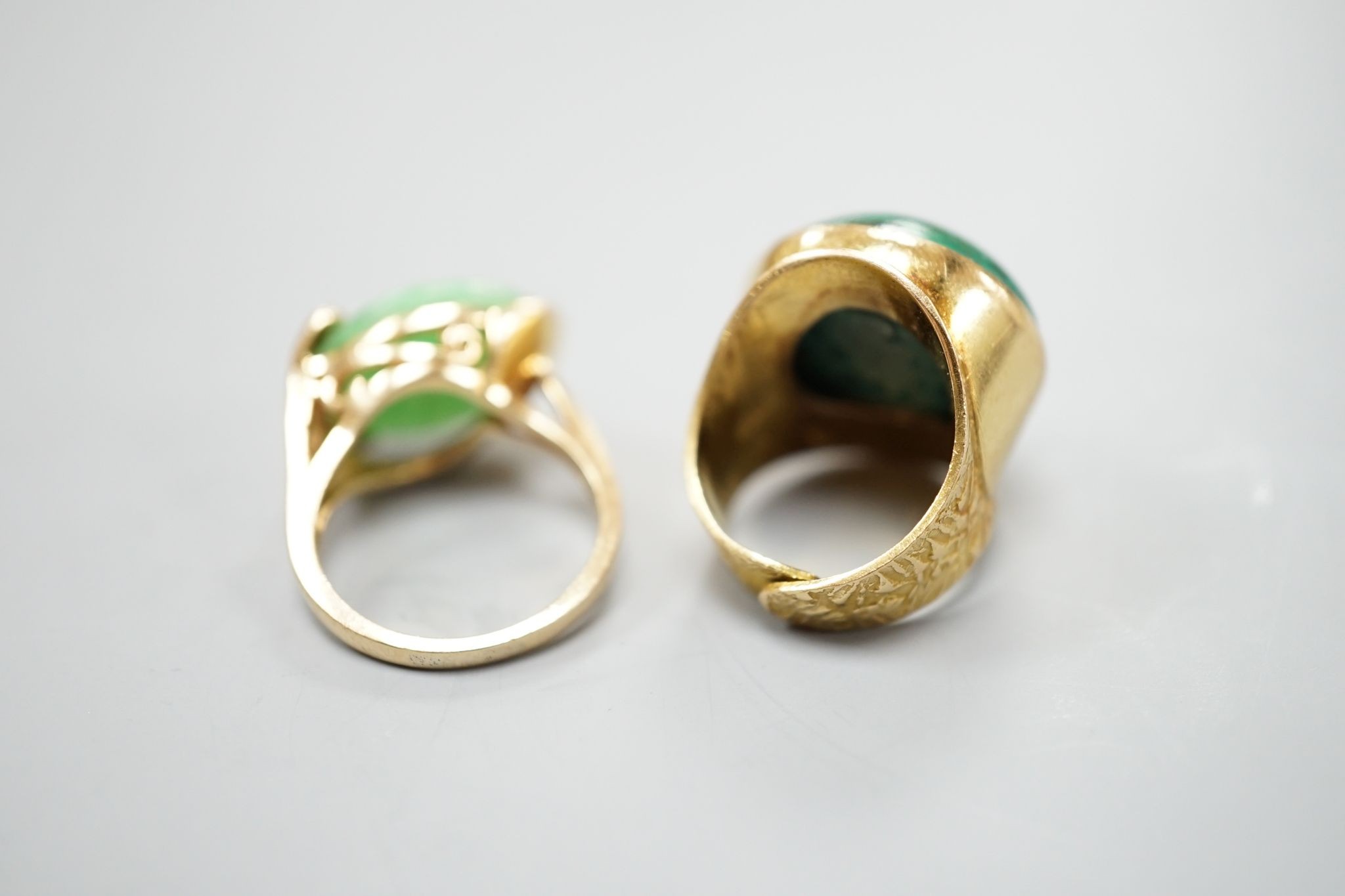 A modern 14k yellow metal and cabochon malachite set dress ring, size F and a similar cabochon jade set ring, size K, gross weight 16.8 grams.